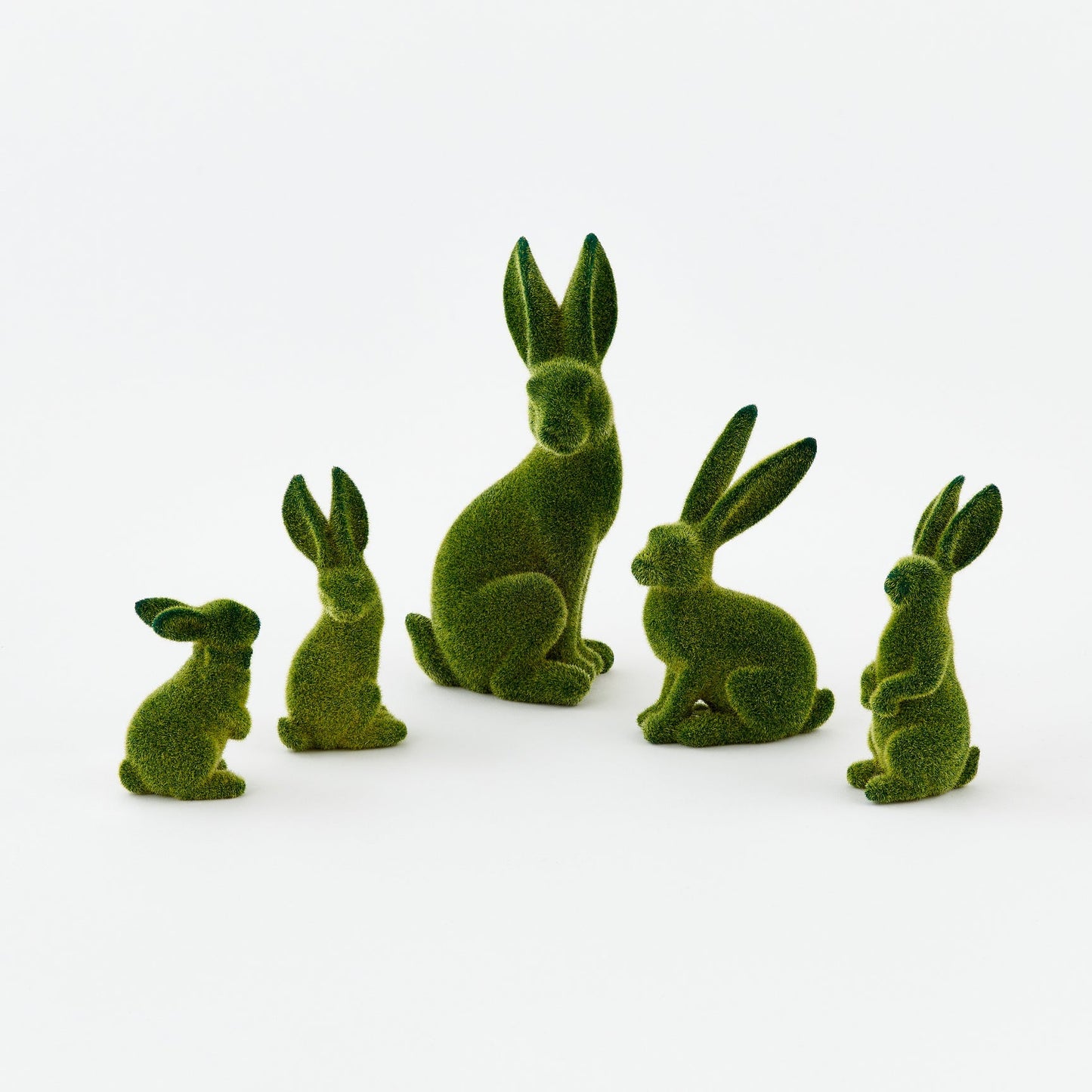 Set of green rabbit figurines on a white background