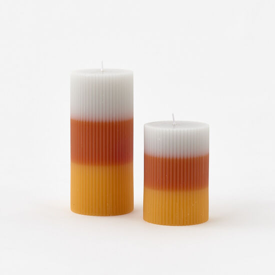 Two layered candles with white, orange, and red colors on a white background
