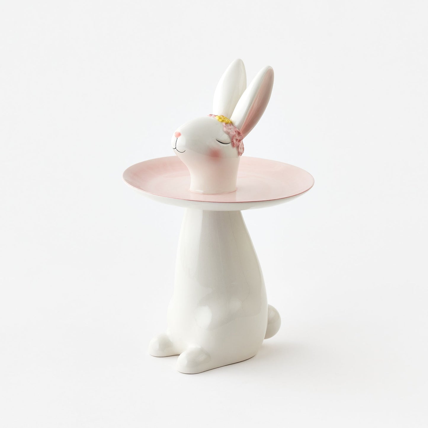 Ceramic rabbit figurine with a pink stand on a white background