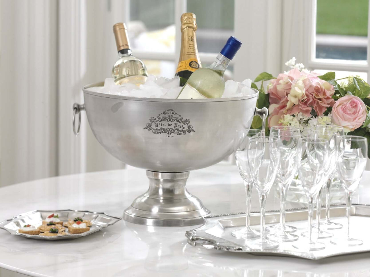 Paris Hotel Collection featuring a champagne bucket with bottles and elegant glassware on a marble table.
