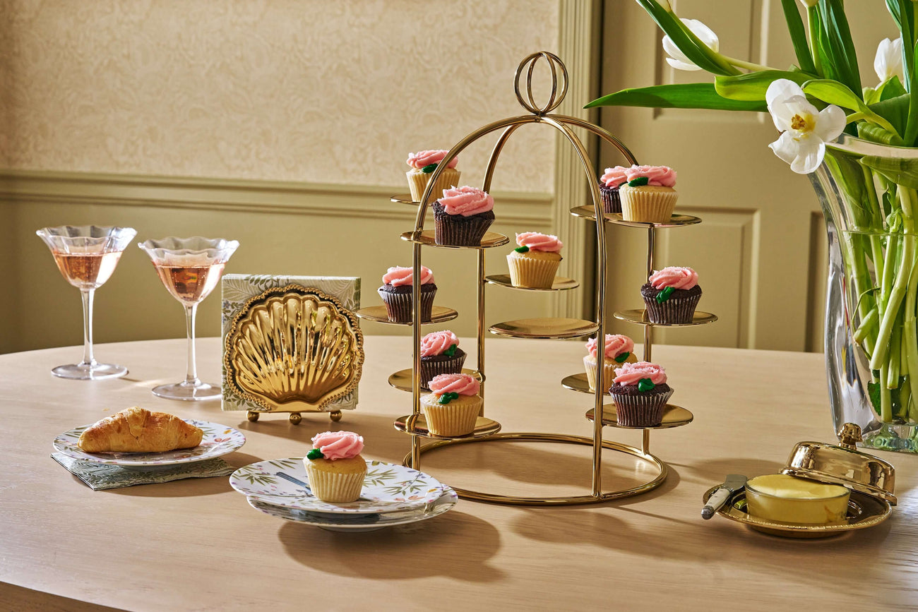 Elegant serveware featuring a stylish cupcake stand, floral plates, and drinks for an elevated dining experience.