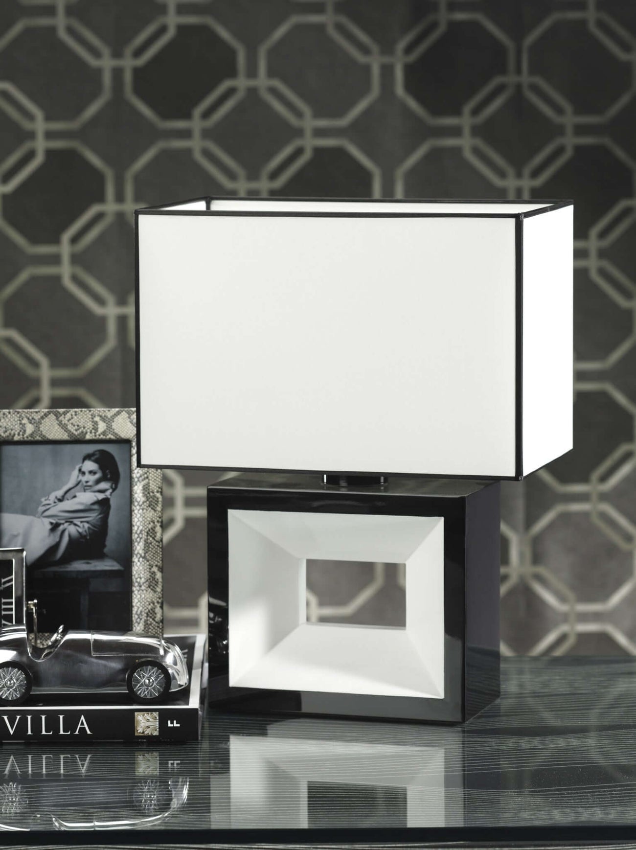 Modern collection lamp with geometric design on a glass table with decor accents.