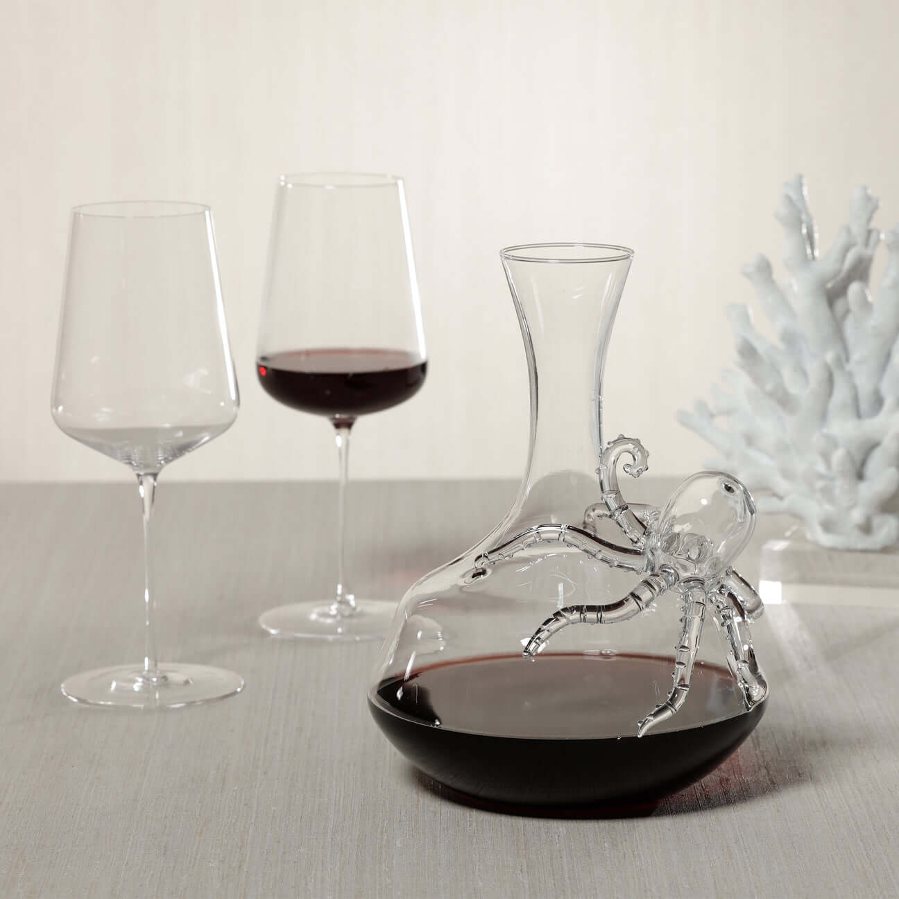 Artistic decanter with octopus design, accompanied by wine glasses, showcasing elegant decanters.