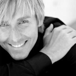 Barclay Butera Collection - Smiling man in black shirt showcasing stylish design.