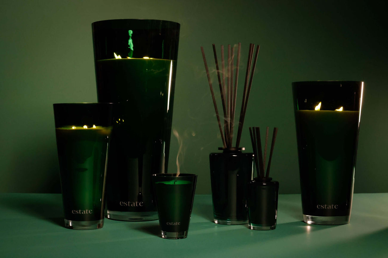 Estate Collection of candles and diffusers featuring dark green designs and natural elements.