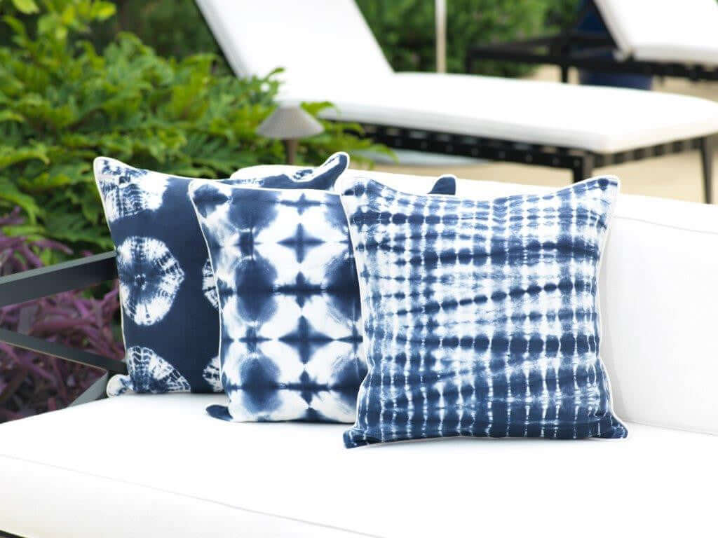 Shop by Color - Blue decorative pillows in various blue patterns on a white couch, adding serenity to outdoor space.