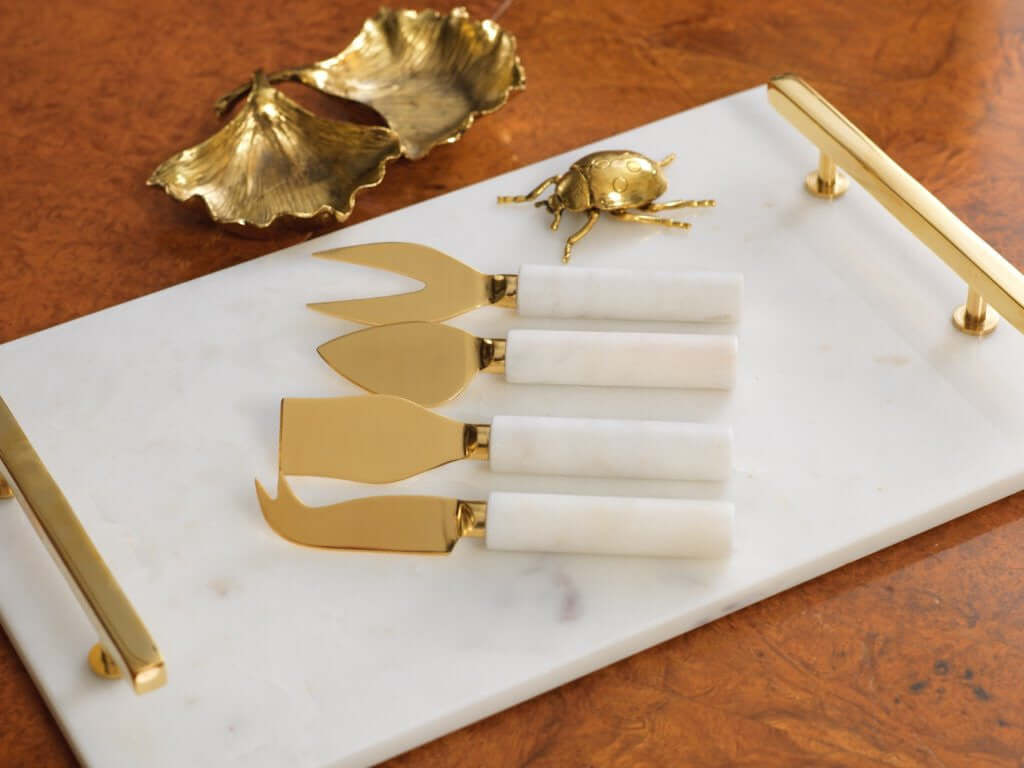 Elegant Marble, Gold, & Agate cheese knives on a marble serving board with a decorative gold beetle.