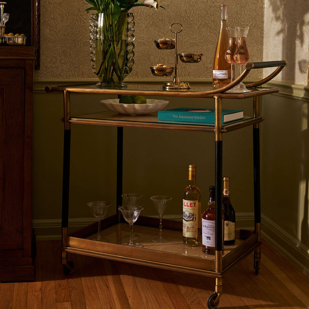 Stylish Mayfair 59 Bar Cart showcasing drinks, elegant glassware, and a decorative bowl on a luxurious antique brass frame.
