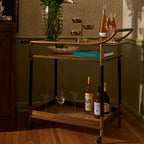 Stylish Mayfair 59 Bar Cart showcasing drinks, elegant glassware, and a decorative bowl on a luxurious antique brass frame.