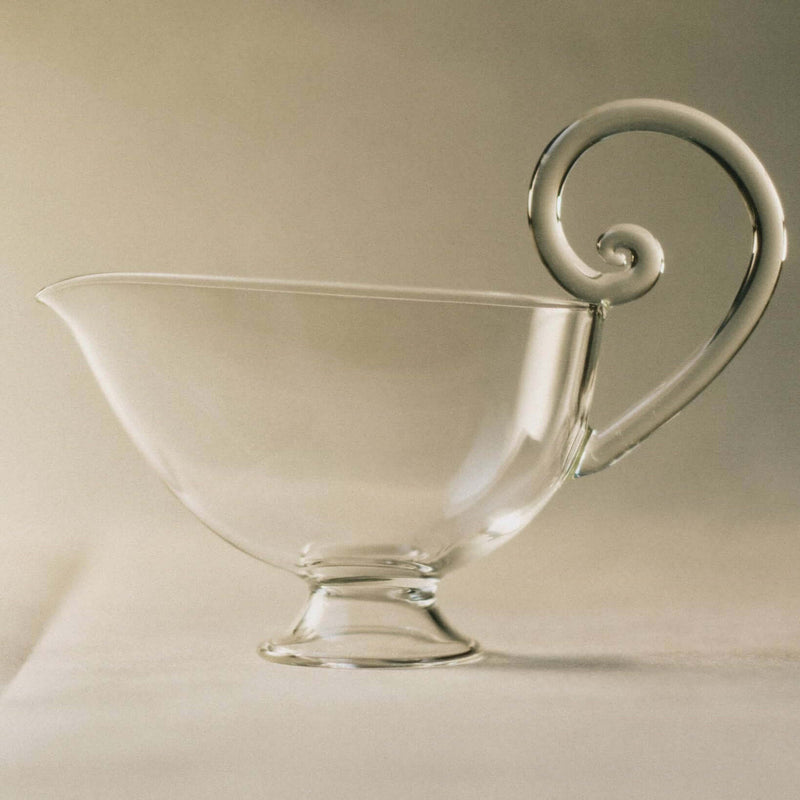 Clear sauciere with decorative handle for serving sauces, 5”H x 7”W, 6 FL OZ / 175 ML.