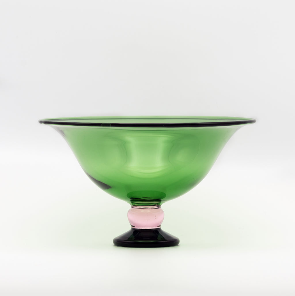 Green glass bowl with a pink base on a white background