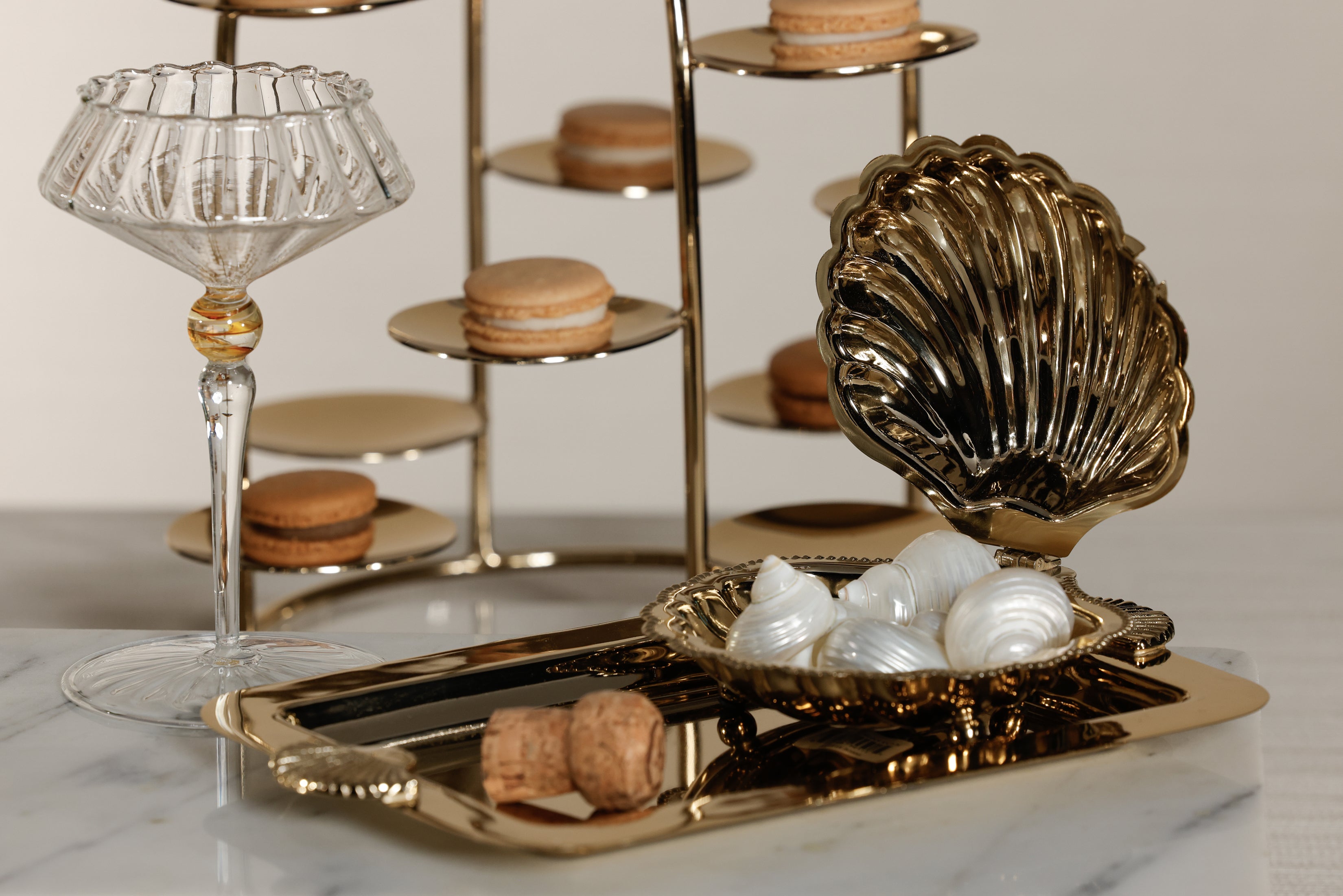 Decorative shell-shaped holder with white items on a marble surface with a blurred background