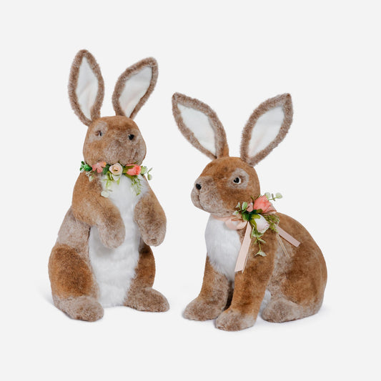 Two plush bunny toys with floral decorations on a white background