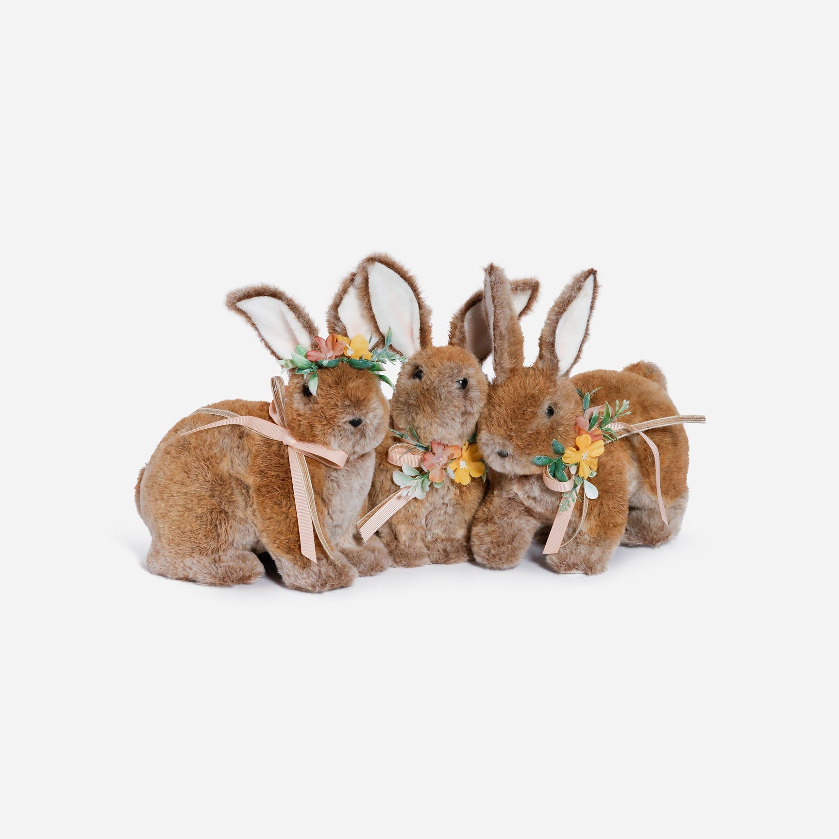 three plush bunny toys with floral decorations on a white background