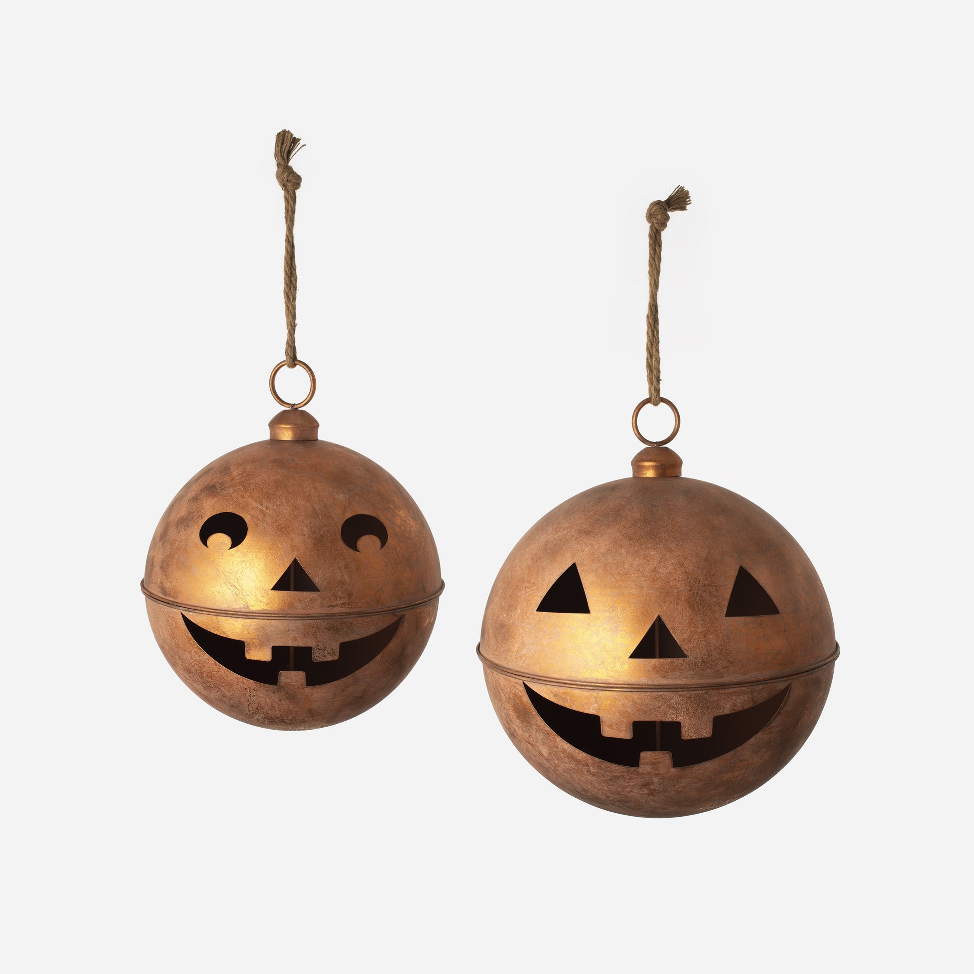 Two copper-colored Halloween lanterns with jack-o'-lantern faces on a white background.