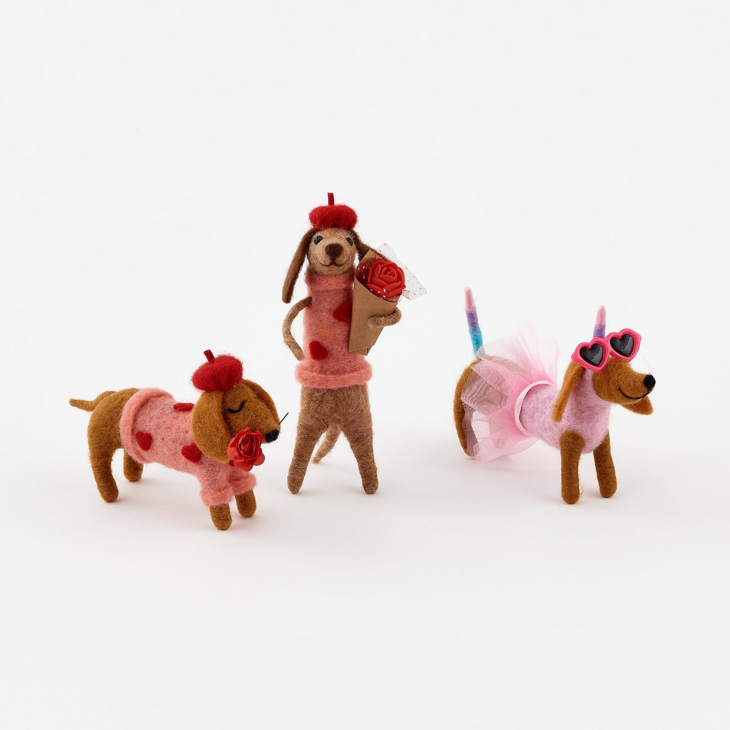 Three felt dog toys on a white background