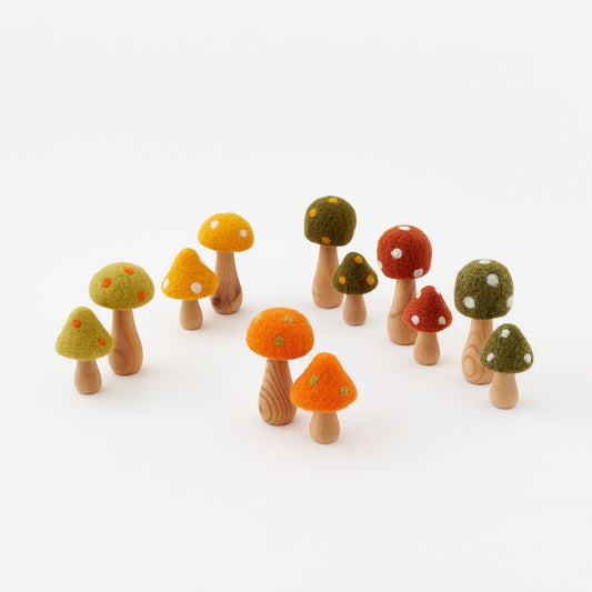 Set of colorful wooden mushroom figurines on a white background