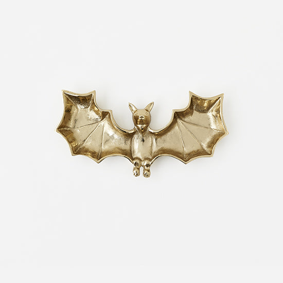 Gold bat-shaped dish on a white background