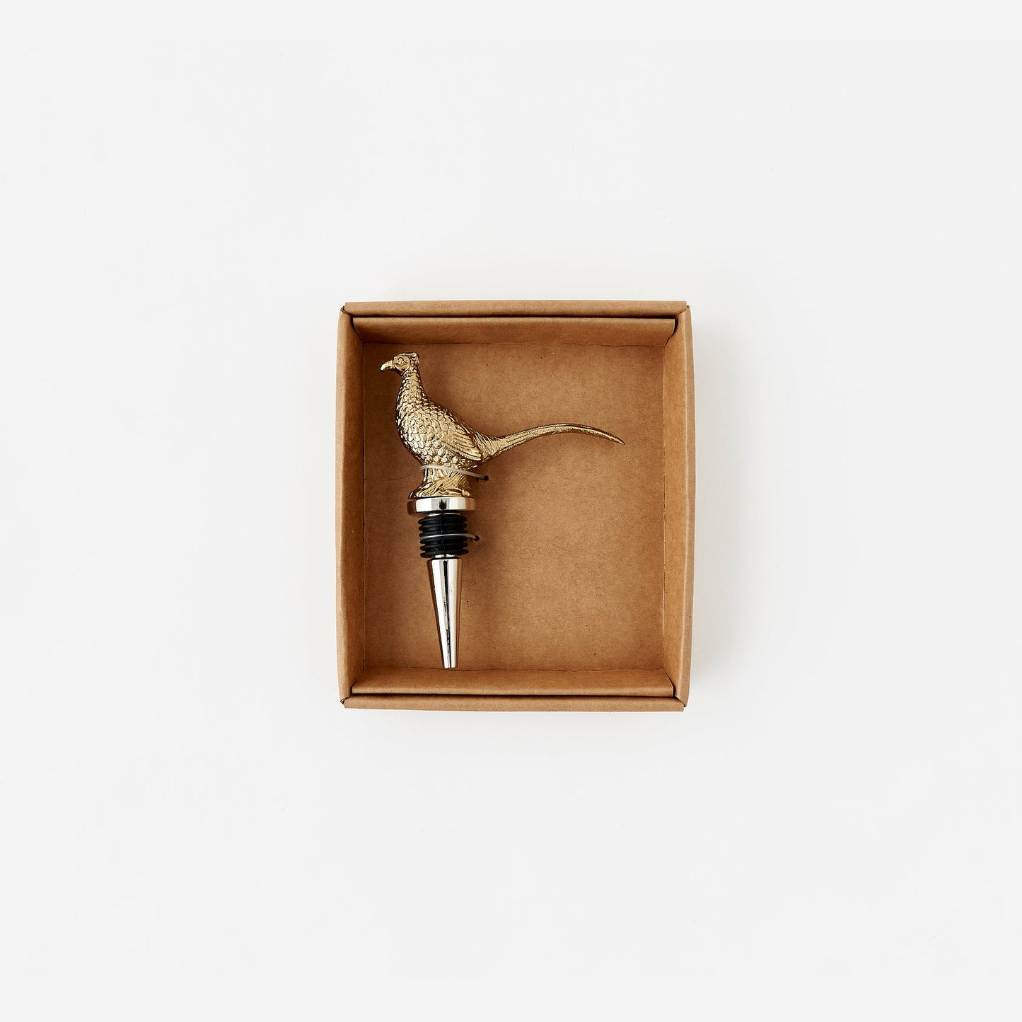Brass pheasant-shaped bottle stopper in a cardboard box on a white background