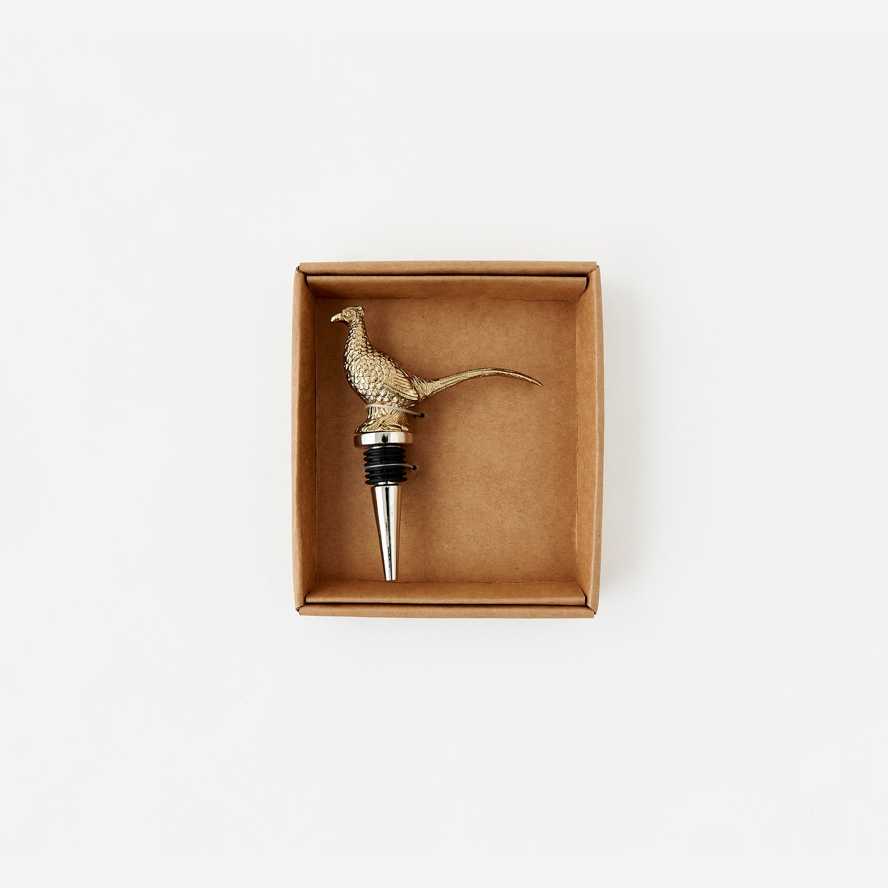 Brass pheasant-shaped bottle stopper in a cardboard box on a white background
