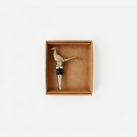 Brass pheasant-shaped bottle stopper in a cardboard box on a white background