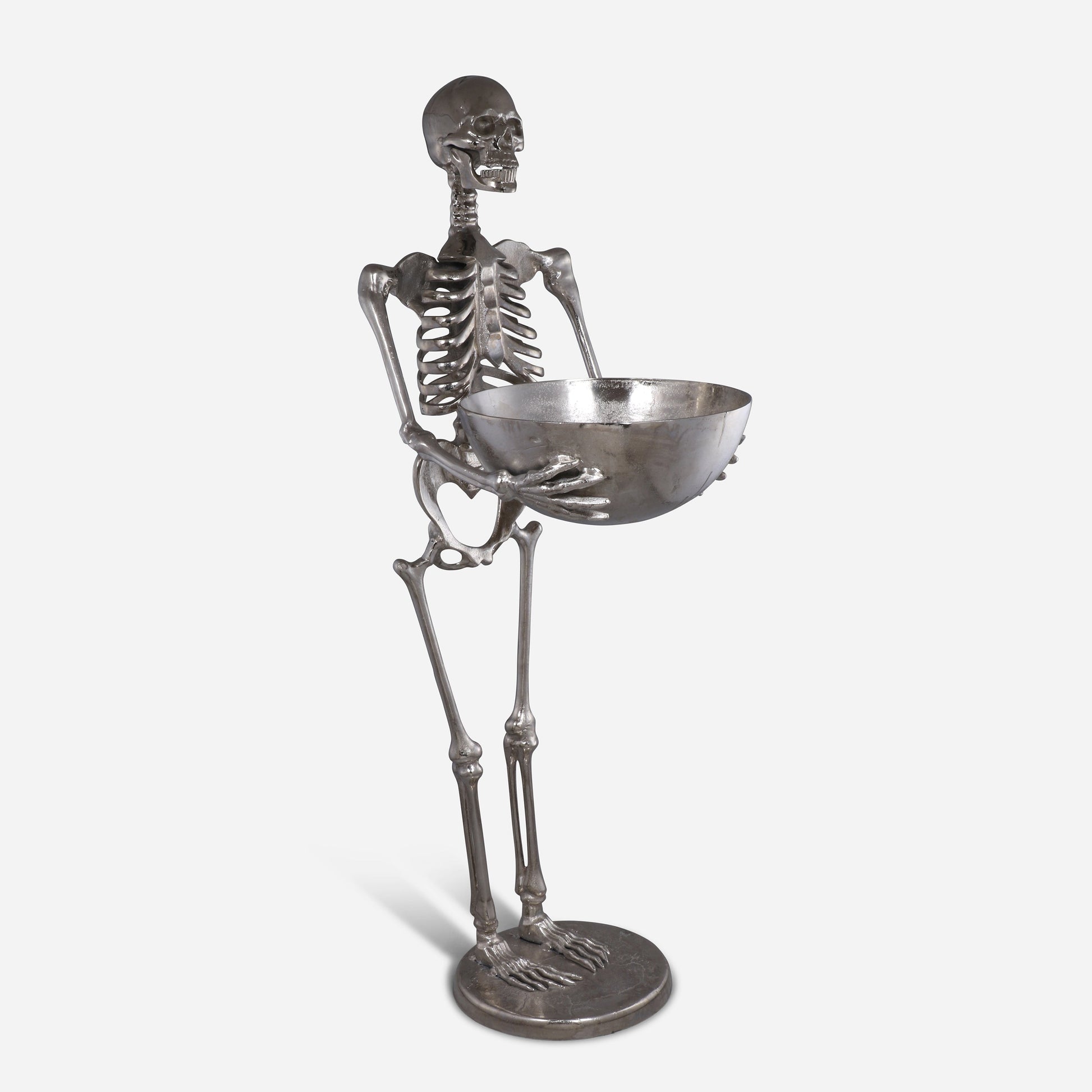 Metallic skeleton figurine holding a bowl on a white background