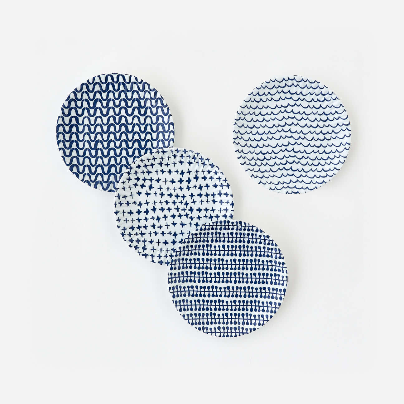 Set of four blue geometric melamine dinner plates inspired by classic paper plate designs.