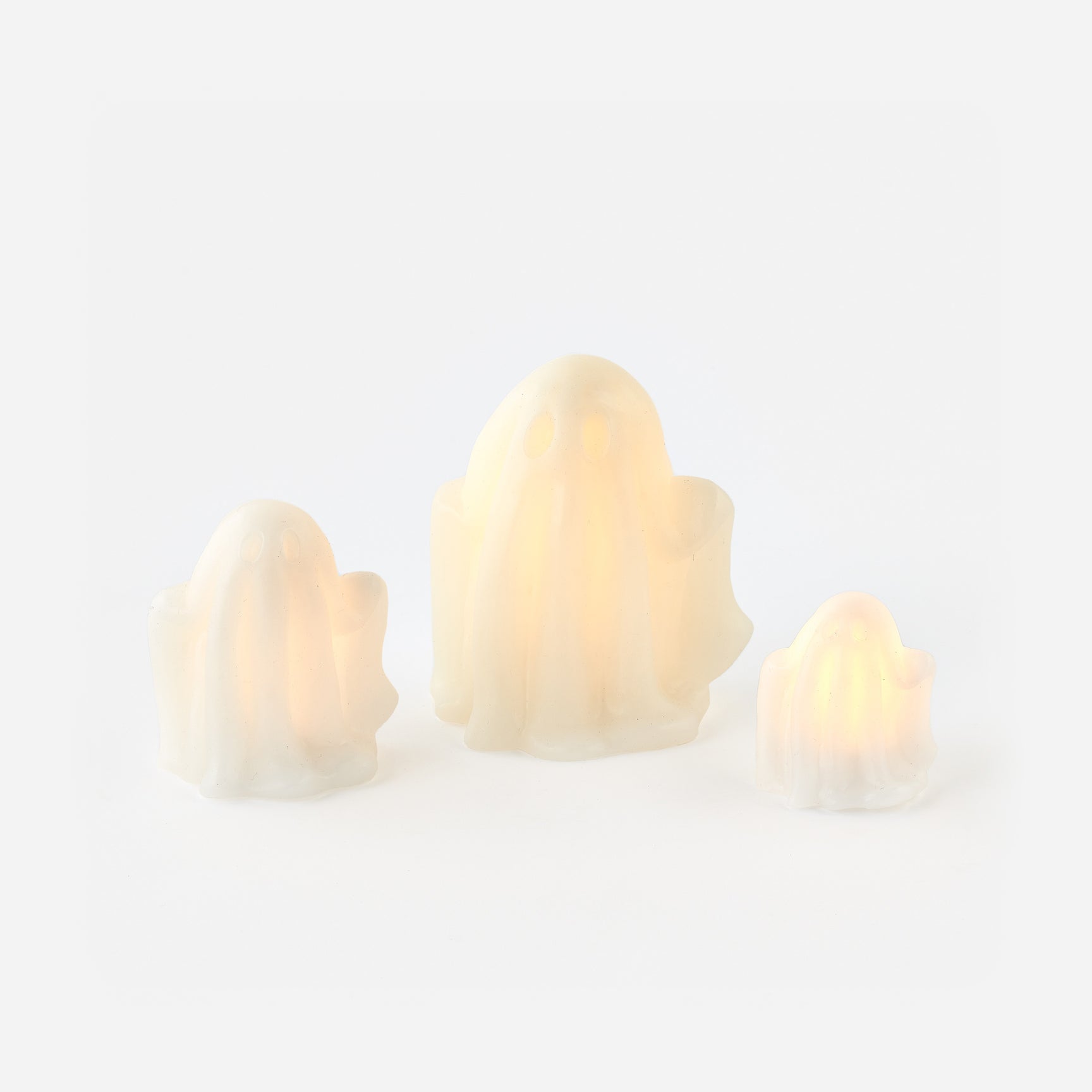 Three lightbulb-shaped candles on a white background