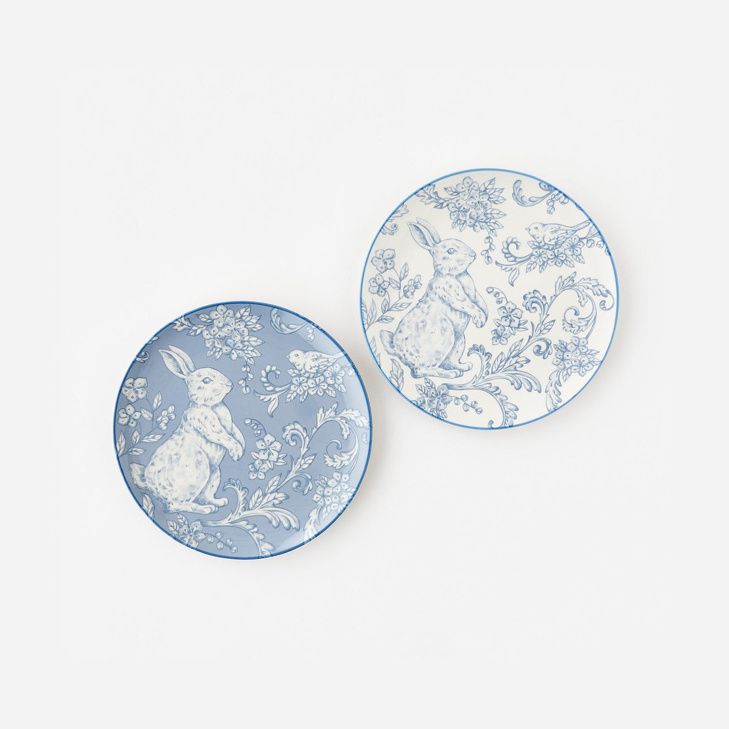 Two decorative plates with rabbit and floral designs on a white background