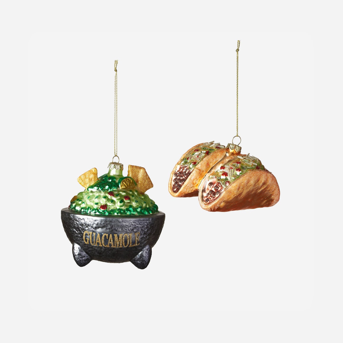 Decorative ornaments shaped like a bowl of guacamole and tacos on a white background