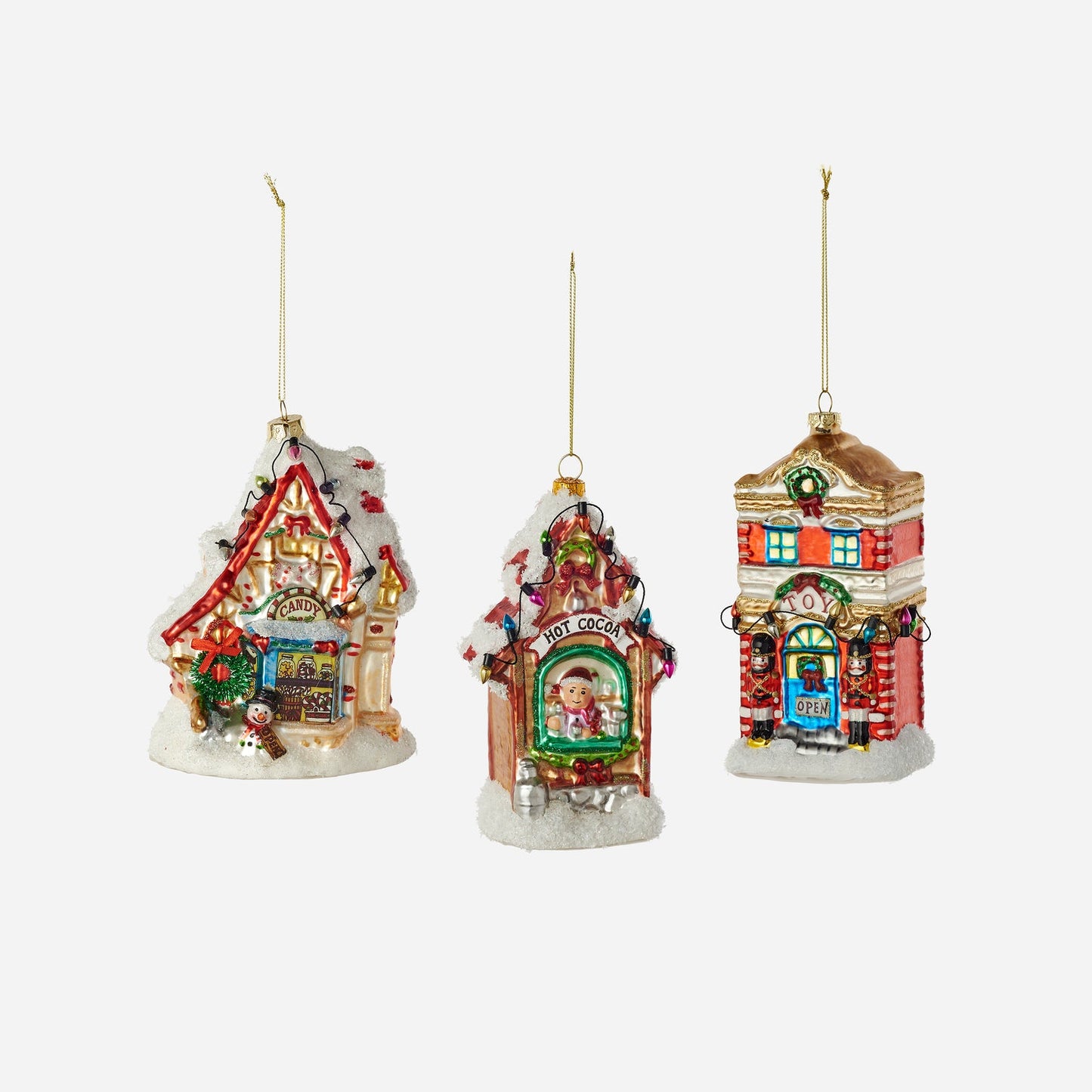 Three colorful Christmas-themed house ornaments on a white background