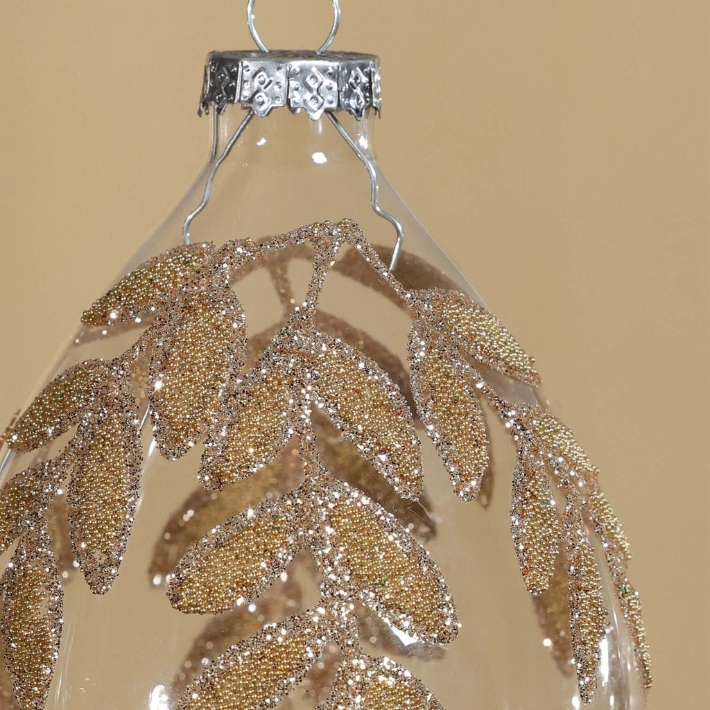 Decorative hanging ornament with gold leaf pattern on a beige background