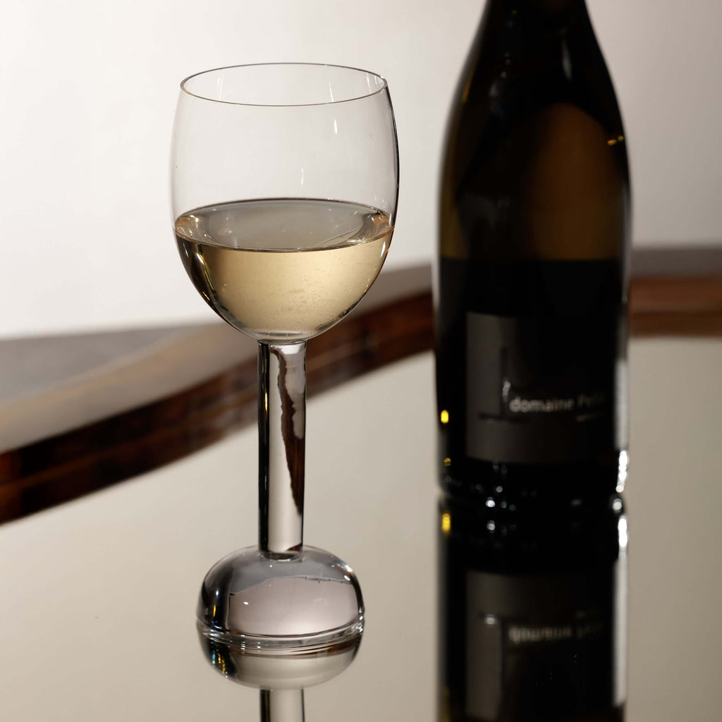 Elegant wine glass from the Madrid Glassware Collection reflecting in a stylish setting.