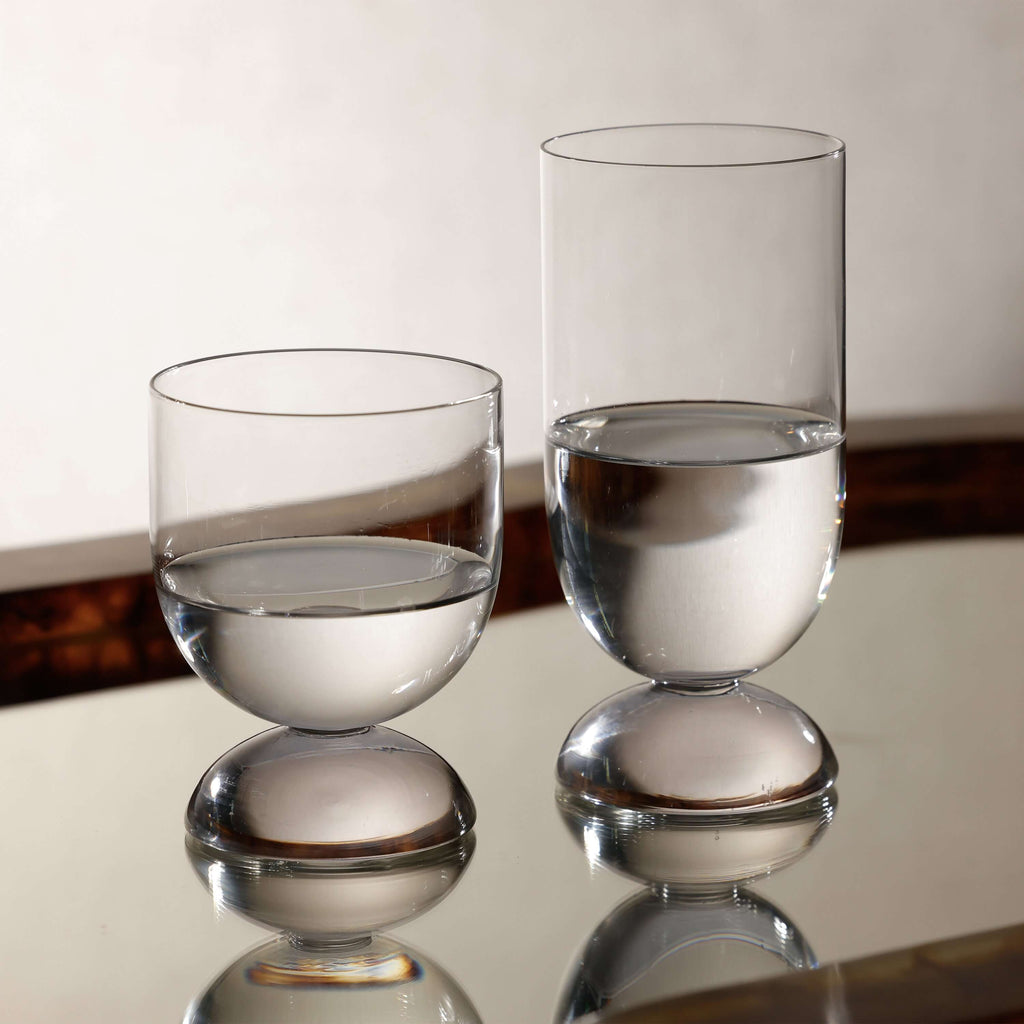 Madrid Glassware Collection featuring elegant glass cups with solid sphere bases, showcasing clear water.