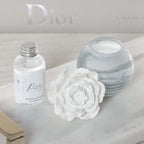 Petals Porcelain Diffuser - Small with marbled glass vessel and delicate porcelain flower on a marble tray.