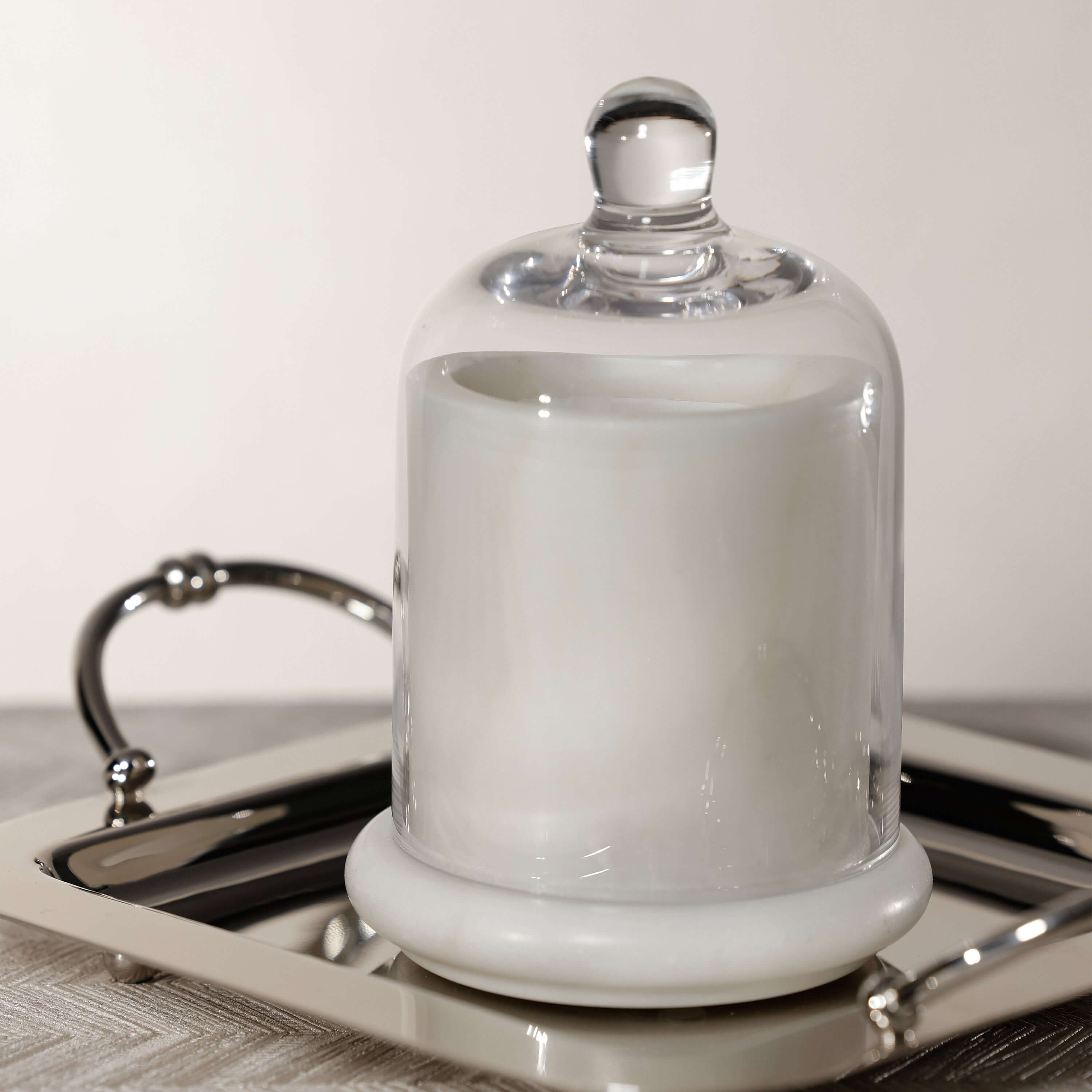 Marbella Scented Candle Jar with Cloche on a shiny tray, featuring a hand-blown glass cloche.