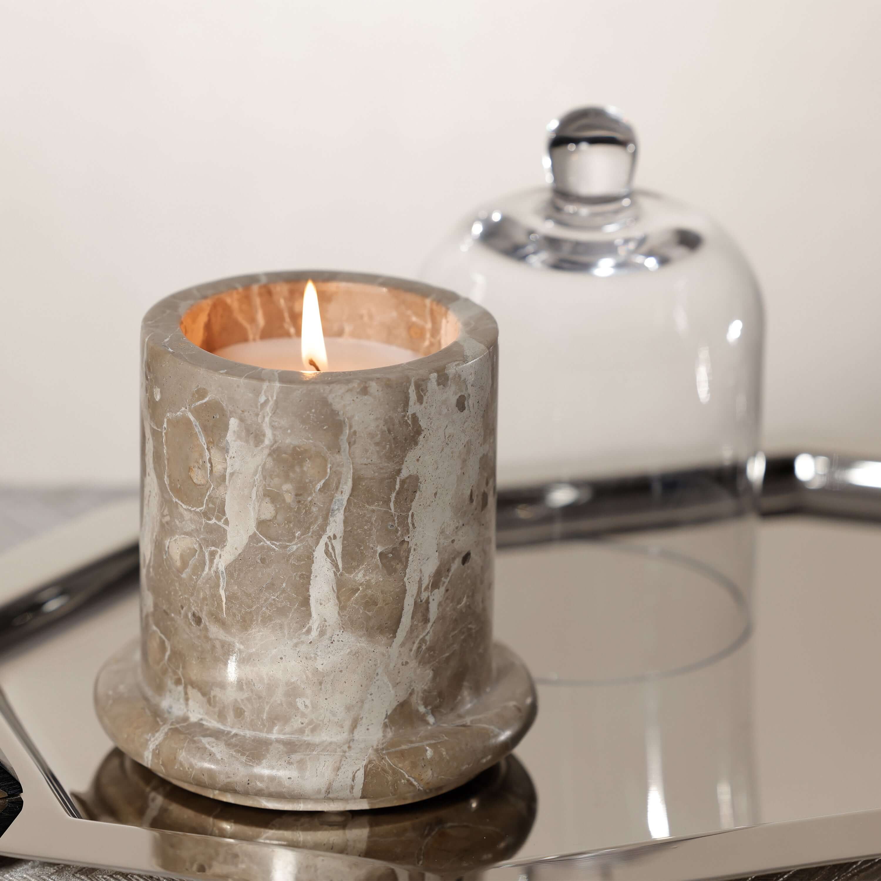 Marbella Scented Candle Jar with Cloche on a mirrored tray, showcasing natural marble and a hand-blown glass cloche.