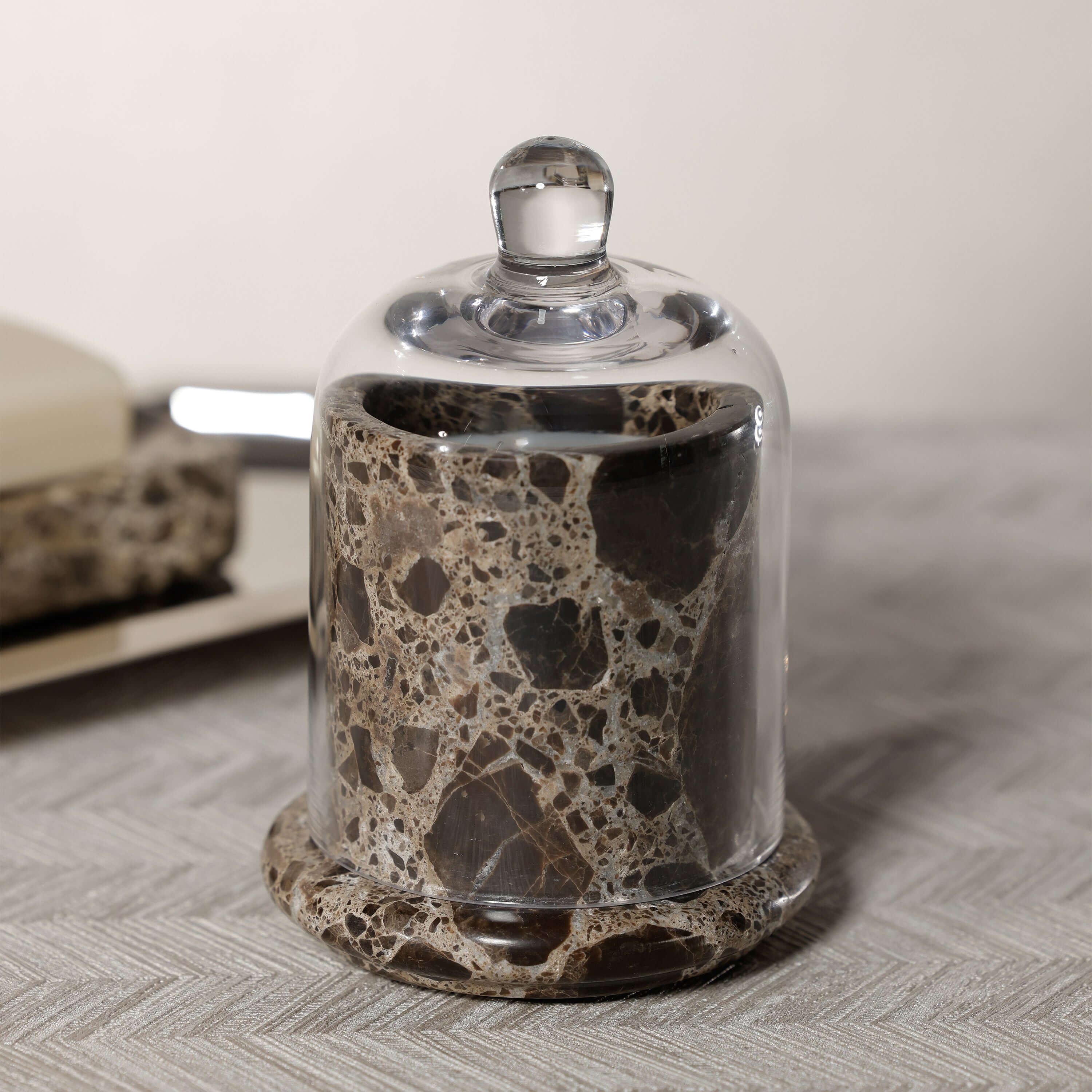 Marbella Scented Candle Jar with Cloche on a textured surface, showcasing natural marble and glass.