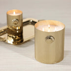 Cap Ferrat Fan Shell Design Candle in Gift Box showcased in a gold fluted vessel with burning wicks.