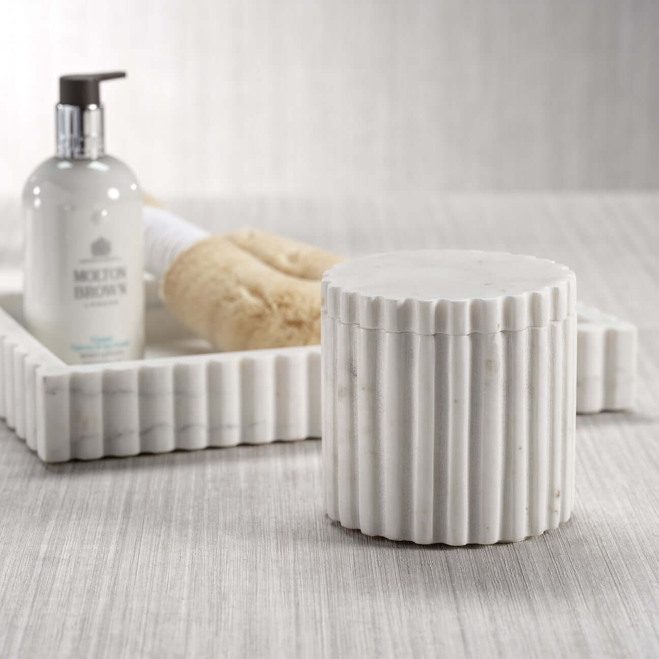 Elegant solid white marble canister from the Camogli Bath Collection with sculpted vertical fluting.