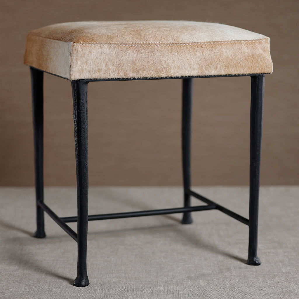 Bar stool with beige cushioned seat and black metal legs on a neutral background