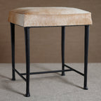 Bar stool with beige cushioned seat and black metal legs on a neutral background