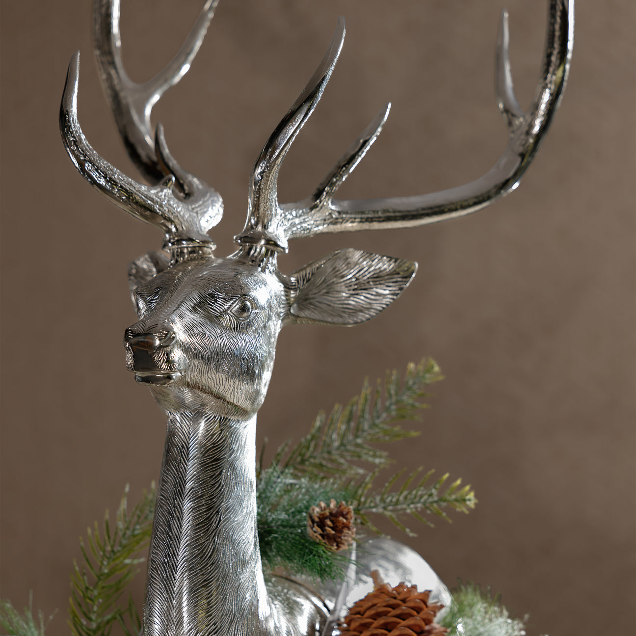 Silver deer ornament with antlers on a brown background
