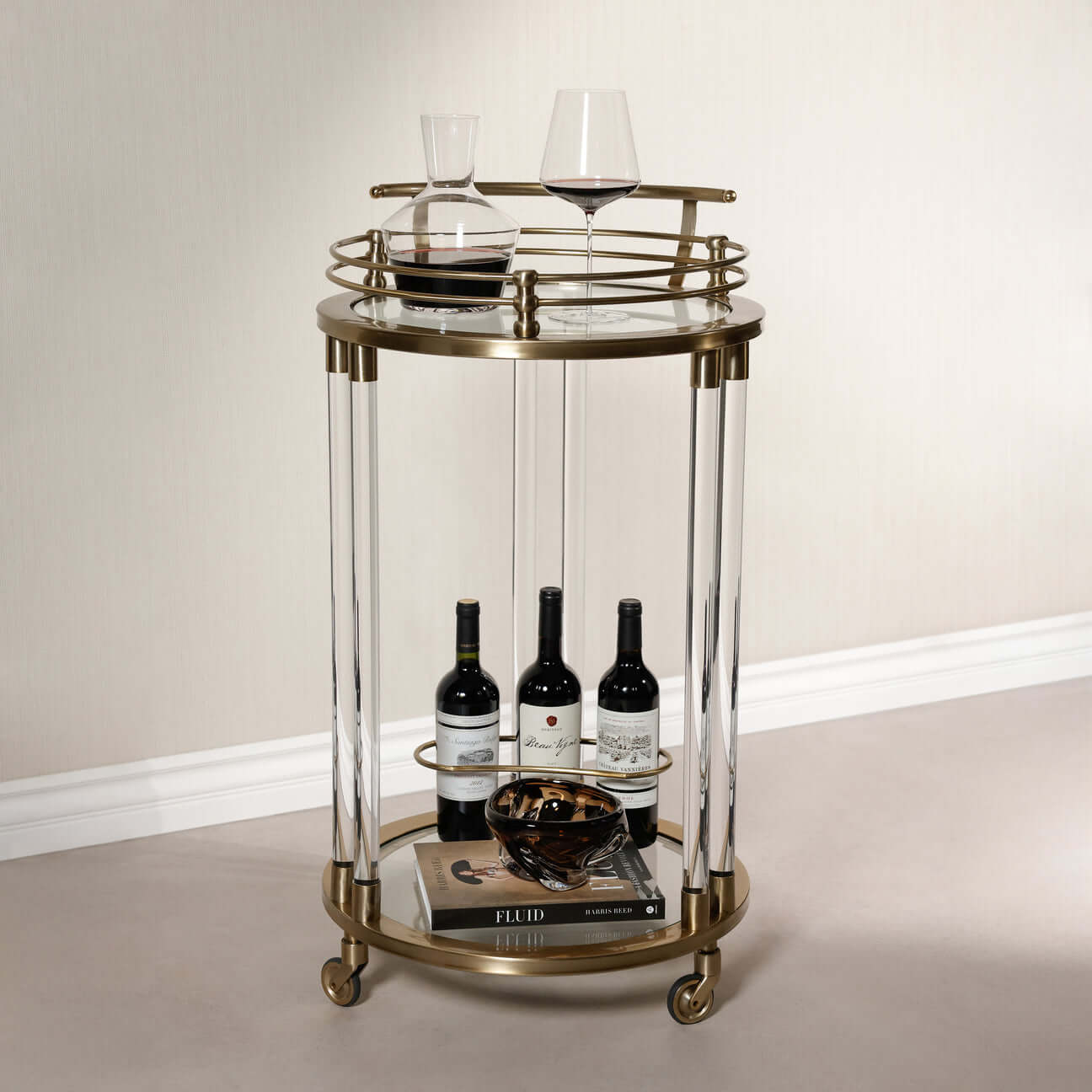 Opus Round Bar Cart / Trolley - Small with brass frame, acrylic legs, and wine storage.