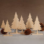 Set of wooden Christmas trees with pine cones on a neutral background
