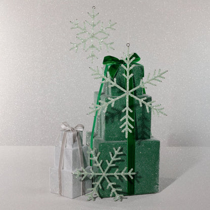Green and silver gift boxes with snowflake decorations on a light gray background