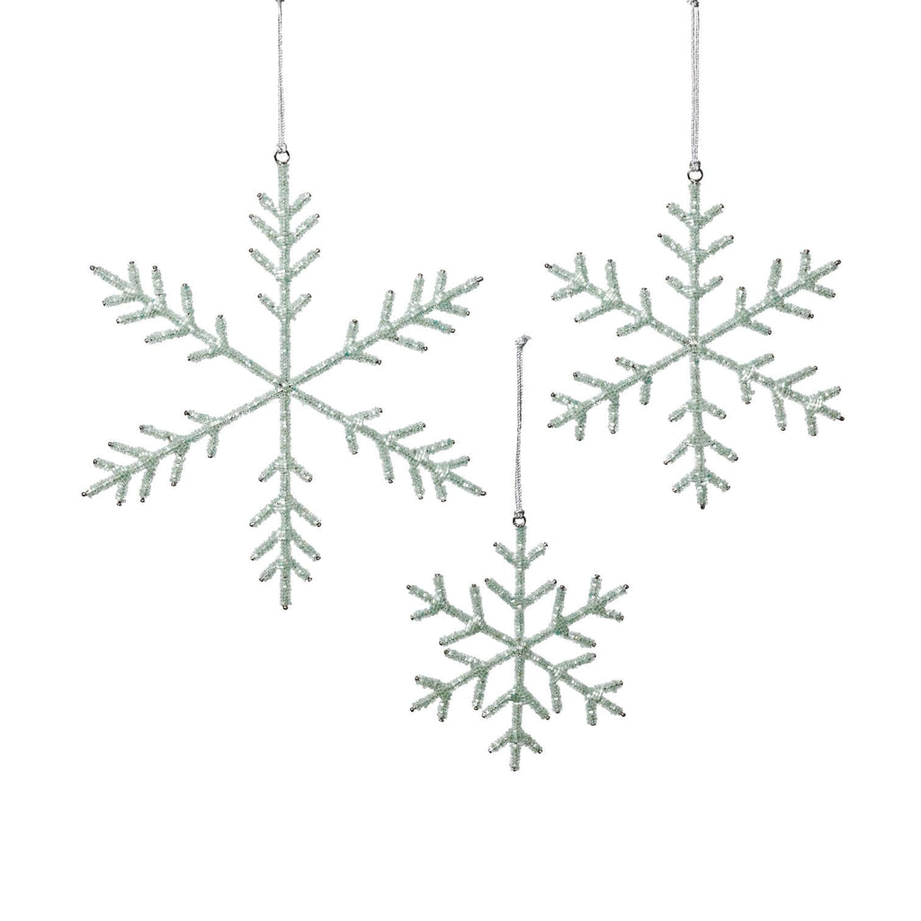 Three snowflake-shaped decorations hanging against a white background