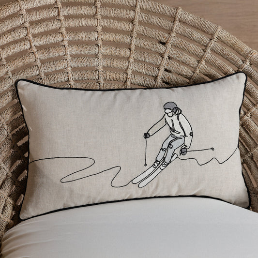Decorative pillow with a skier design on a textured chair