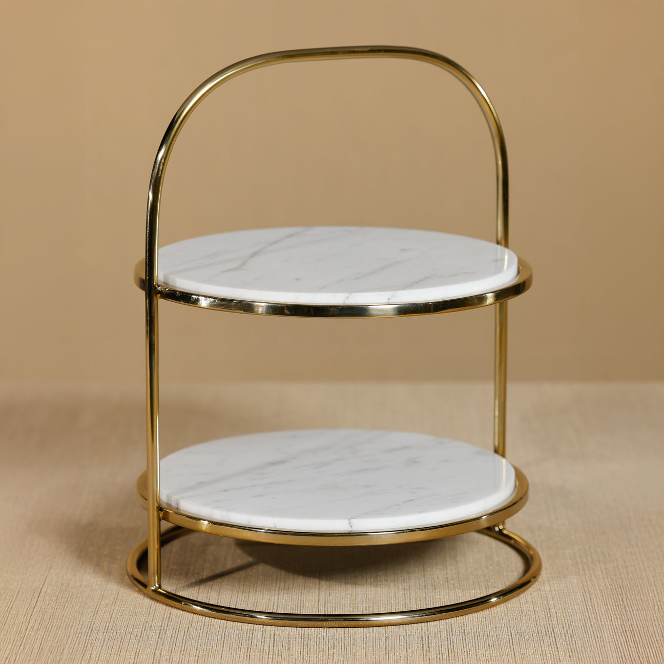 Two-tiered gold and marble stool on a beige background