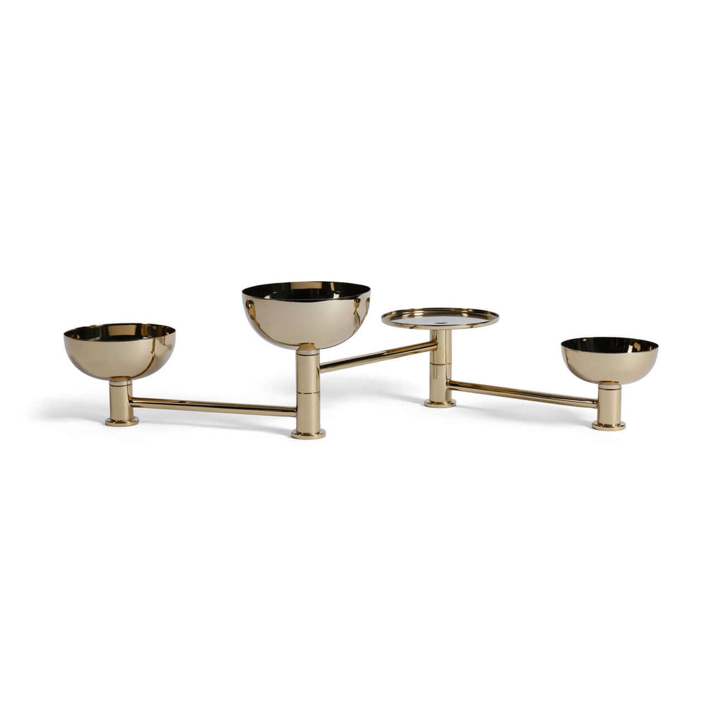 Brass condiment set with four bowls on a white background